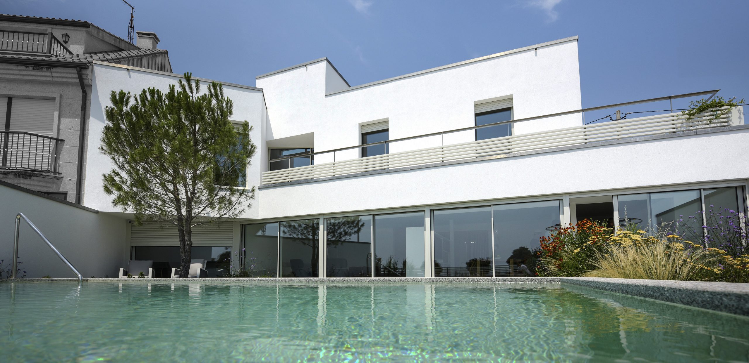 Casa Aguiño, piscina y fachada principal. Recuna Arquitectos.